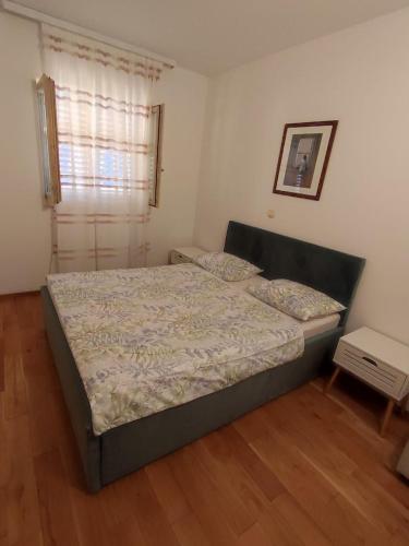 a bedroom with a bed and a window at Apartment Ela with private jacuzzi in Podgora