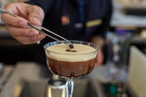 a person stirring a drink in a glass at Intercontinental Real Guatemala by IHG in Guatemala