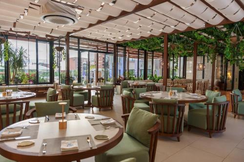 a restaurant with tables and chairs and windows at Intercontinental Real Guatemala by IHG in Guatemala