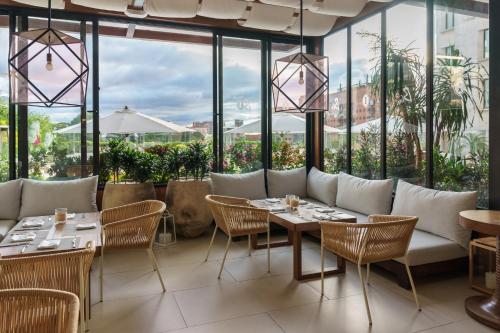 a restaurant with tables and chairs and large windows at Intercontinental Real Guatemala by IHG in Guatemala
