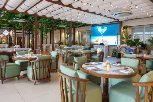a restaurant with tables and chairs and a screen at Intercontinental Real Guatemala by IHG in Guatemala