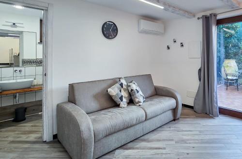 a couch in a living room with a clock on the wall at Domus Minerva in Massa Lubrense