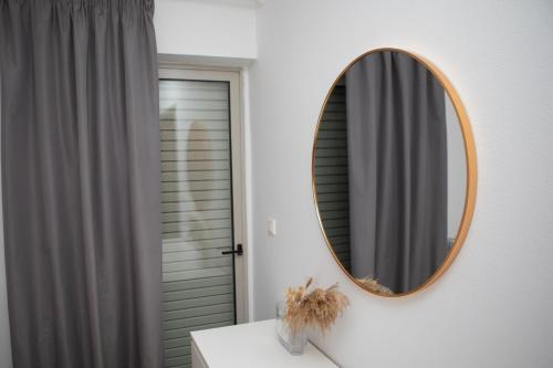 a mirror on a wall above a bathroom sink at Relax & Stay in Xanthi