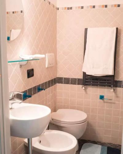 a bathroom with a white toilet and a sink at Il Grecale - The Cliff Retreat in Corniglia