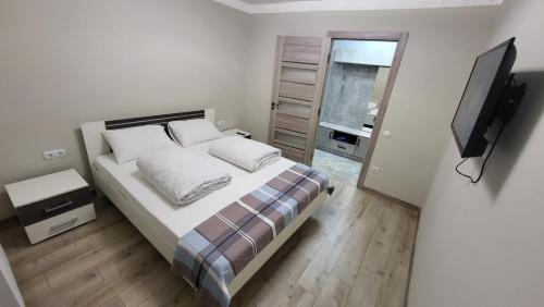 a bedroom with a bed and a flat screen tv at 2-х кім.квартира в центрі Берегова in Berehove