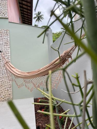 a hammock hanging from the side of a building at Pousada Praia Bela in Ilhéus