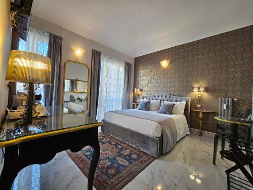 a bedroom with a bed and a desk and a mirror at Dorolea Rooms Torino Centro in Turin