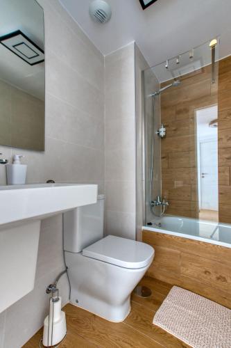 a bathroom with a toilet and a sink and a tub at South facing sea views Isea in Torrox Costa