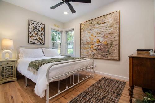a bedroom with a bed and a painting on the wall at Beautiful Benson Cottage with Year-Round Hot Tub in Omaha