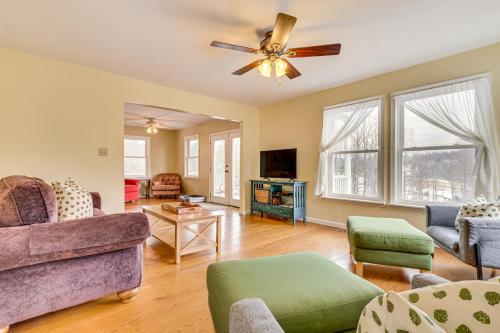 a living room with a couch and a ceiling fan at Family Home with Game Room and Decks in Etlan! in Etlan