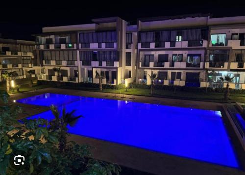 a swimming pool in front of a building at night at Appartement Les Crêtes in Casablanca