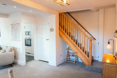 a living room with a staircase and a couch at Camellia Cottage With Private Garden in Bowness-on-Windermere