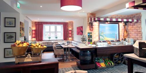 a kitchen and living room with a counter with fruit in a bowl at Park Hotel Sellin in Ostseebad Sellin