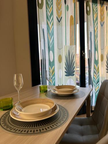 a dining room table with plates and wine glasses at Turin Bicerin Green in Turin