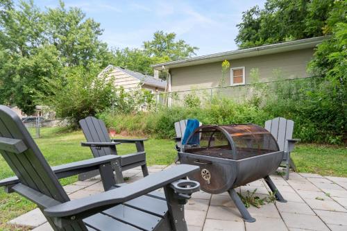 a grill sitting on a patio with two chairs at Peaceful Gem HotTub Fenced Yard & Near Downtown in Omaha