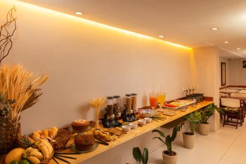 a buffet of food on a long wooden shelf at Hotel Villa Reggia in Rio de Janeiro