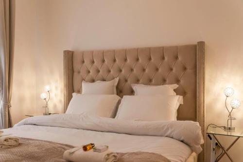 une chambre avec un grand lit avec des draps et des oreillers blancs dans l'établissement Villa Saint Honore, à Serris