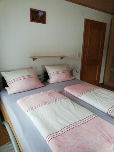 two beds in a room with pink and white pillows at Ferienwohnung Ruth und Ewald Matt in Herrischried