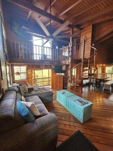 a living room with two couches and a table at Tropical Treehouse In Paradise St Thomas in East End