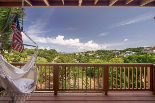 a porch with a hammock and a view of the ocean at Tropical Treehouse In Paradise St Thomas in East End