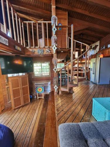 a large room with wooden floors and stairs in a cabin at Tropical Treehouse In Paradise St Thomas in East End