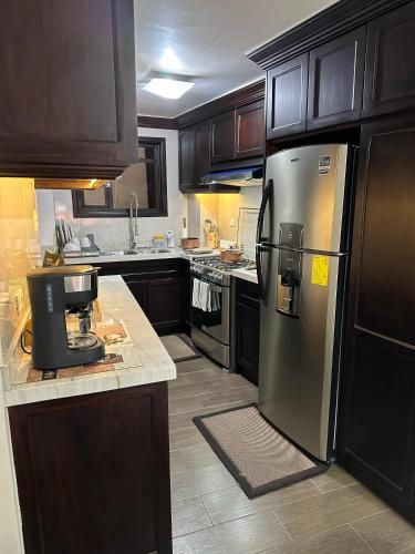 kuchnia ze stalową lodówką i drewnianymi szafkami w obiekcie Millers Townhouse w mieście Ibarra
