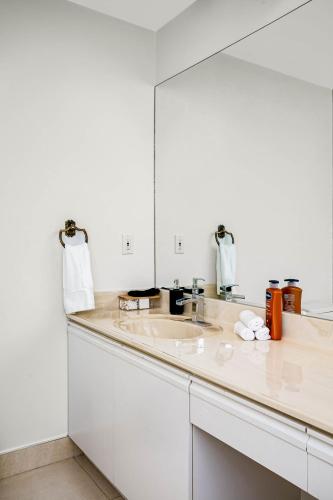 a white bathroom with a sink and a mirror at Chic Central 4BDRM Home-King Bed-AirHockey-Mins DT in Edmonton