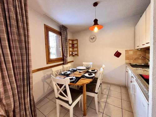 - une table à manger et des chaises dans la cuisine dans l'établissement Résidence Le Bois Du Fau - APPARTEMENT T2 BOIS DU FAU PRES DES PISTES MAE-1031, à Vars