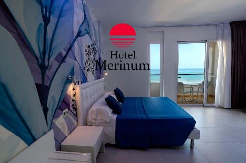 una camera da letto con un letto e vista sull'oceano di Hotel Merinum a Vieste