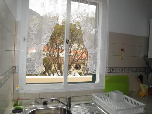 a kitchen sink with a window with a view of a building at Apartment Alameda with Sea View in Machico