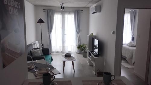 a living room with a couch and a tv and a table at Ameli in Neuquén