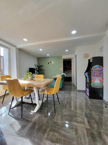 une salle à manger avec une table et des chaises en bois dans l'établissement Casa Bella - Clim, Extérieur, Jeux arcade, à Thiers