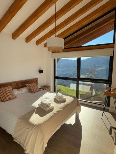 a bedroom with a bed and a large window at Aire de Picos Norte in Brez