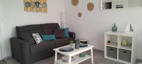 una sala de estar con un sofá y una mesa en Très beau Studio Cosy à 500m de la Plage, en Gruissan