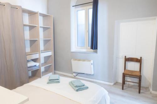 une chambre avec un lit, une chaise et une fenêtre dans l'établissement Havre Midi - TV, Wifi, Cosy - Centre Ville, à Montélimar