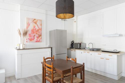 une cuisine avec une table et un réfrigérateur dans l'établissement Havre Midi - TV, Wifi, Cosy - Centre Ville, à Montélimar