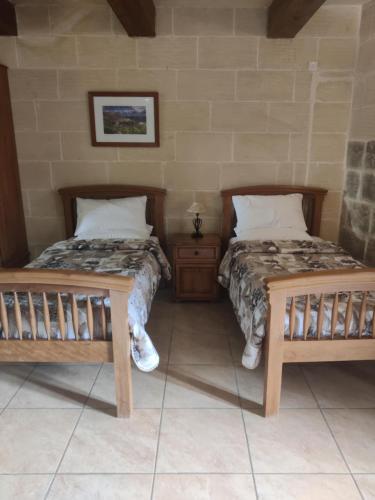 two beds sitting next to each other in a room at Tan-Namur Farmhouse B&B in Xewkija