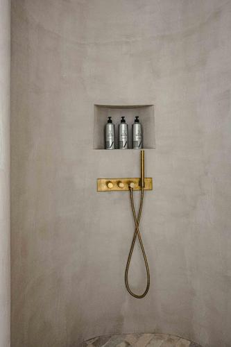 a shelf with three bottles on a wall at 1.75 Paris La Source in Paris