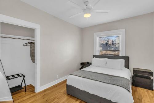 a white bedroom with a bed and a window at City of Fountains Getaway in Kansas City