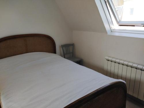 un lit dans une petite pièce avec une fenêtre dans l'établissement Douarnenez Centre avec vue mer, à Douarnenez