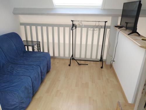 un salon avec un canapé bleu et une télévision dans l'établissement Douarnenez Centre avec vue mer, à Douarnenez