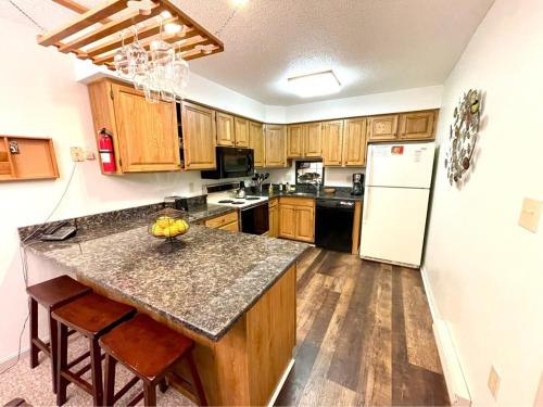 a kitchen with wooden cabinets and a counter top at Lincoln Condo with slope view in Lincoln