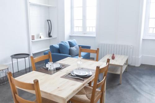 une salle à manger avec une table et un canapé bleu dans l'établissement Havre Doux - TV, Wifi, Élégant - Centre Ville, à Montélimar