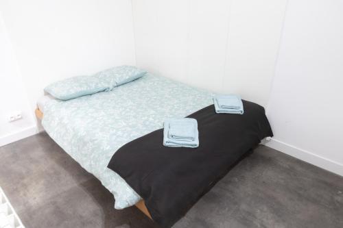 une chambre avec un lit avec deux serviettes dessus dans l'établissement Havre Doux - TV, Wifi, Élégant - Centre Ville, à Montélimar