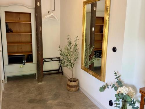 a hallway with a mirror and a plant in a basket at Wisteria Österlen in Simrishamn