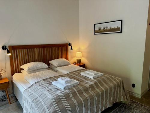 a bedroom with a bed with two towels on it at Wisteria Österlen in Simrishamn