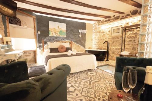a bedroom with a bed and a couch in a room at Lo Raconet d'Arnes in Arnés
