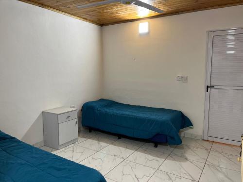 a room with two beds and a night stand in it at Yateí in Puerto Iguazú