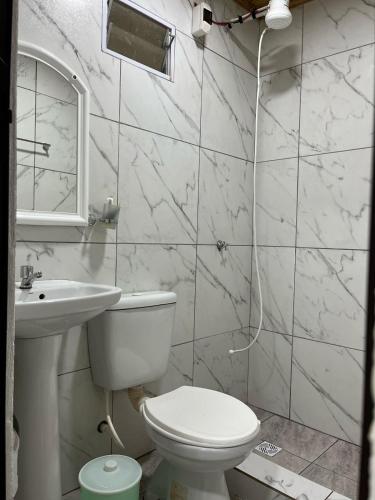 a white bathroom with a toilet and a sink at Yateí in Puerto Iguazú