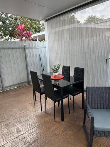 a black dining table and chairs on a patio at Comfortable modern apartment- central location. in Miami